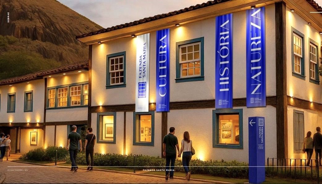 Fachada do Complexo Fazenda Santa Maria, em Muniz Freire, com prédio histórico iluminado e banners do projeto cultural, turístico e ambiental.