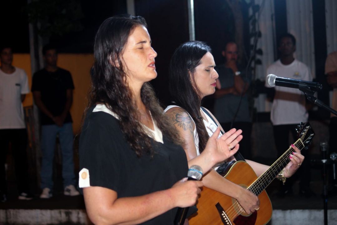 Mulheres participam de momento de louvor durante o evento cristão Despertai Ibitirama, realizado em frente à Prefeitura Municipal.