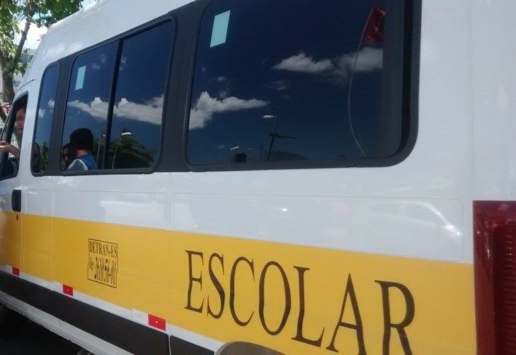 Veículo de transporte escolar identificado com faixa amarela, utilizado para o deslocamento de estudantes da rede municipal.