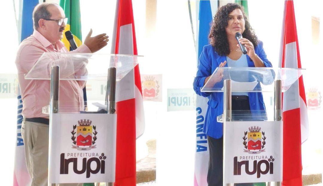 Prefeito de Irupi discursa em púlpito com a identidade visual da Prefeitura durante cerimônia de entrega do Kit Mulher Viva+, com bandeiras oficiais ao fundo, destacando ações de fortalecimento da rede de proteção às mulheres, e secretária de Estado das Mulheres, Jaqueline Rocha, fala ao público em púlpito da Prefeitura de Irupi durante entrega do Kit Mulher Viva+, ressaltando políticas públicas de combate à violência contra a mulher.