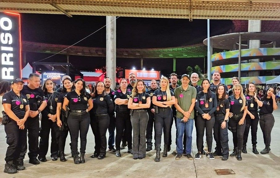 Equipe da Polícia Civil do Espírito Santo reunida durante ação de conscientização no Carnaval, com agentes uniformizados em espaço de evento noturno.