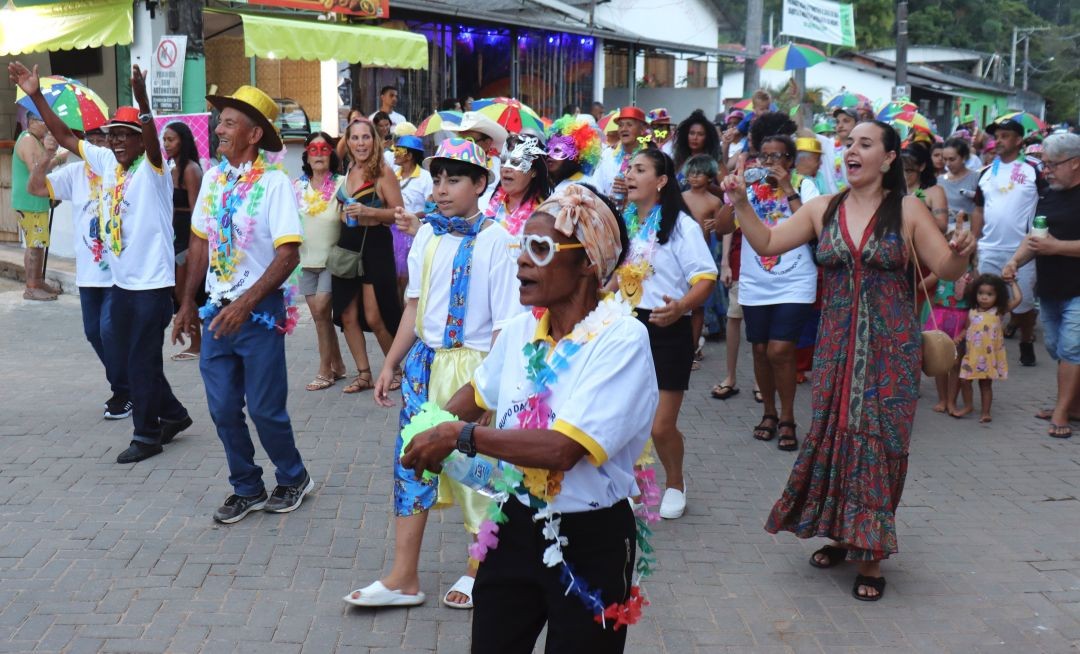 Integrantes do Bloco da Terceira Idade desfilam pelas ruas de Patrimônio da Penha, na folia do Carnaval 2026, vestindo camisetas personalizadas do grupo..