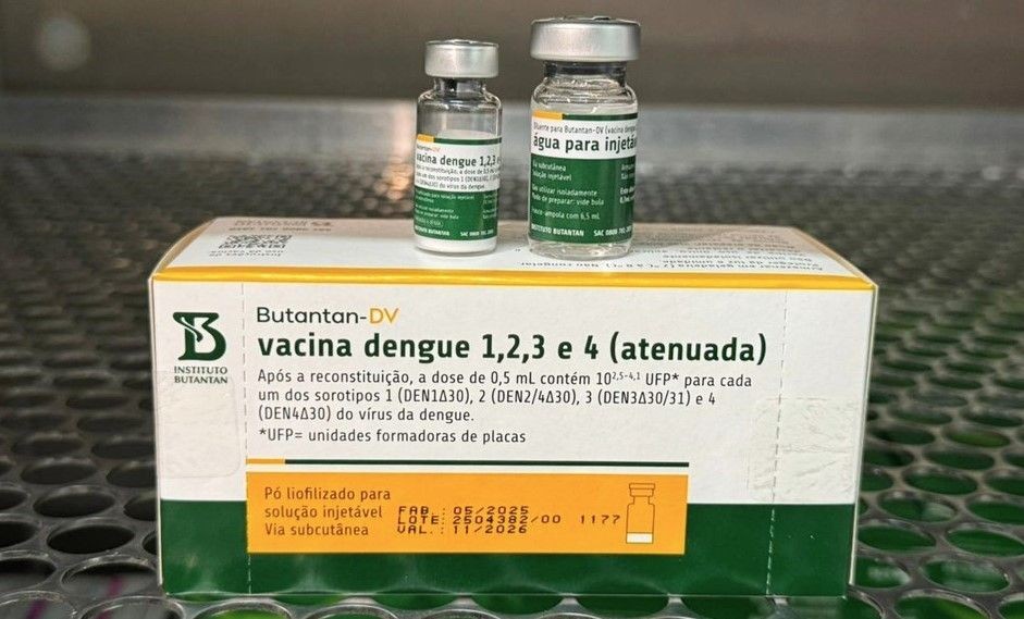 Caixa da vacina contra dengue Butantan-DV, desenvolvida pelo Instituto Butantan, com dois frascos do imunizante posicionados sobre a embalagem, em ambiente laboratorial.