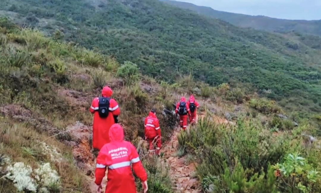 Equipe do Corpo de Bombeiros realiza buscas em trilha íngreme no Parque Nacional do Caparaó, em meio à vegetação de montanha.