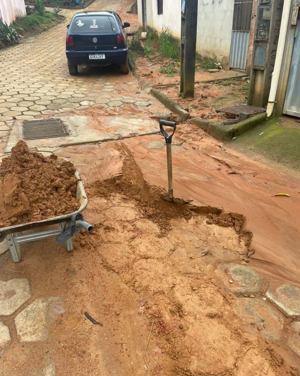 Rua com acúmulo de lama e sedimentos sendo removidos por equipes da Prefeitura de Ibitirama após temporal.