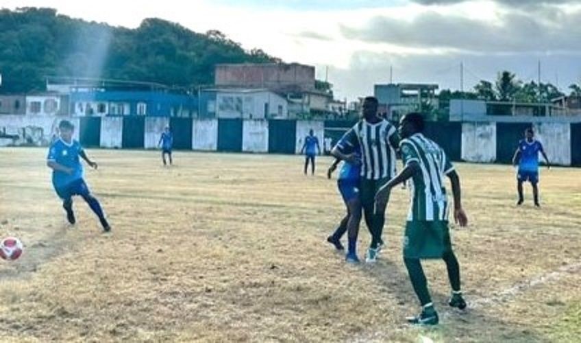 Jogadores de Itapemirim e São José do Calçado disputam lance em campo de futebol com gramado seco durante partida da Copa Sesport no interior do Espírito Santo.