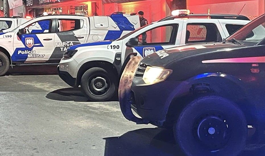 Fotografia em ângulo baixo mostrando três viaturas da Polícia Militar do Espírito Santo estacionadas próximas umas das outras durante a noite. Os veículos possuem as cores branco e azul, com o logotipo da corporação e a inscrição 