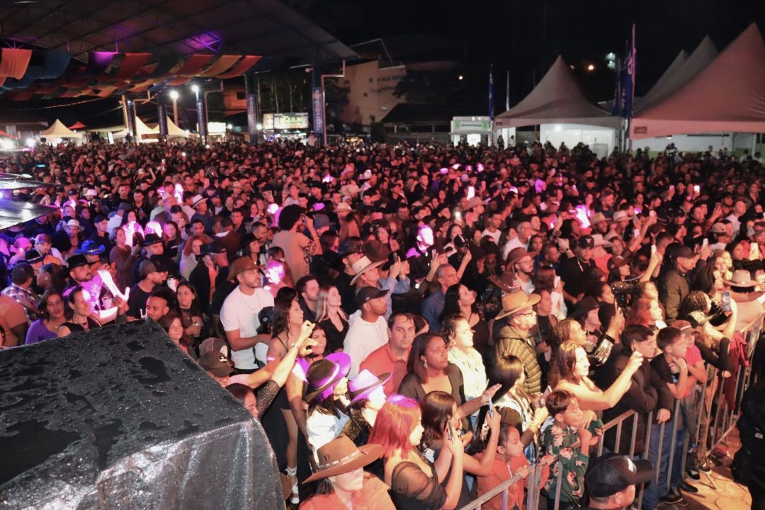 Público numeroso acompanha show na Expoagro de Patrimônio da Penha, reunido em frente ao palco, com pessoas próximas à grade de proteção e iluminação noturna sobre a plateia.