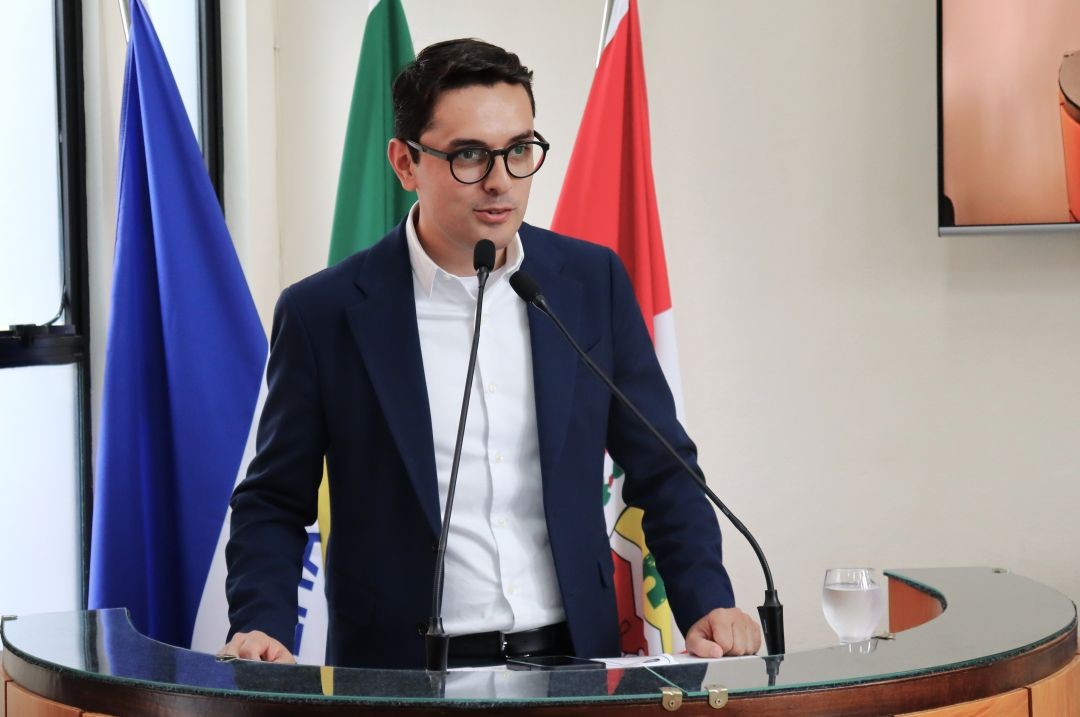 Prefeito em exercício, Abercílio Machado, de óculos e blazer azul discursa no púlpito da Câmara Municipal de Irupi durante a abertura do ENFOC 2026.