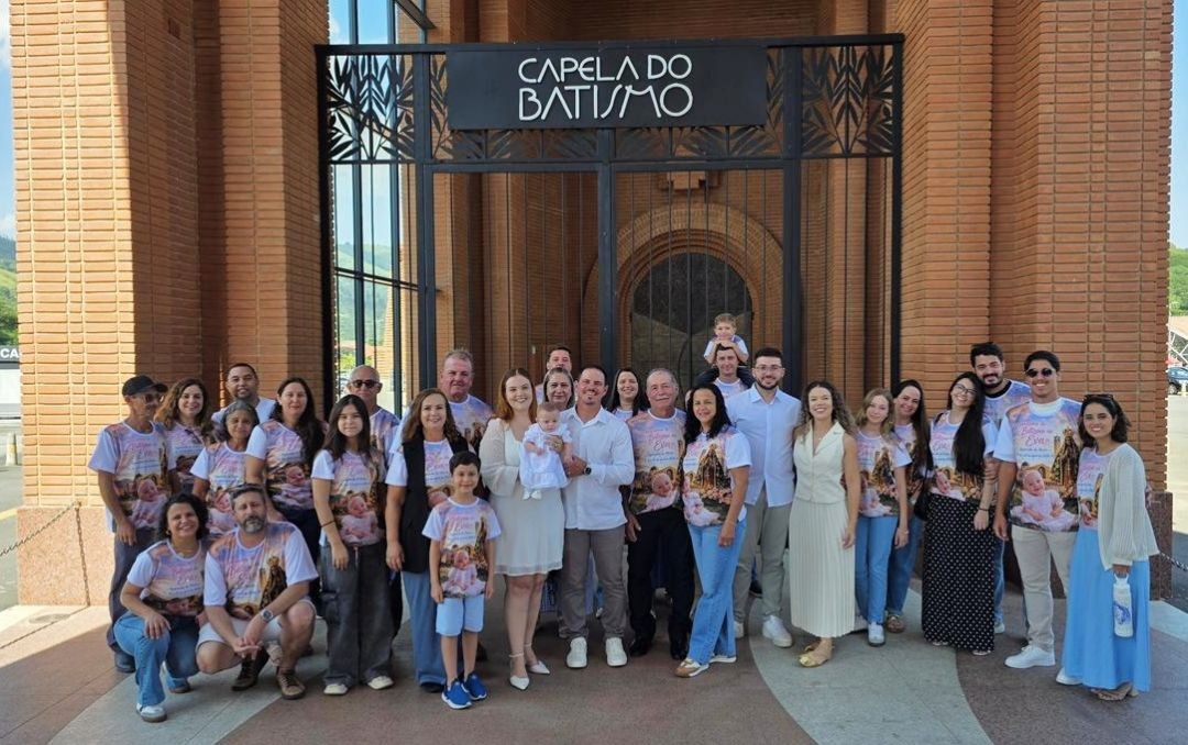 Grande grupo de familiares reunido em frente à entrada da 