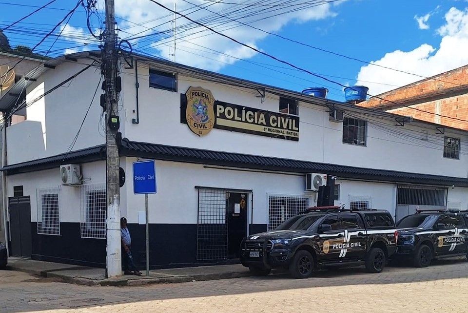 Fachada de uma delegacia da Polícia Civil em Ibatiba, com viaturas estacionadas em frente durante o dia.