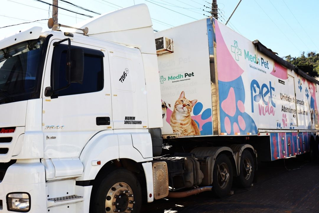 Carreta da unidade móvel do Programa Pet Vida estacionada em rua de Divino de São Lourenço. O veículo, equipado para atendimento veterinário e cirurgias de castração, exibe imagens de cães e gatos e a identificação do programa.