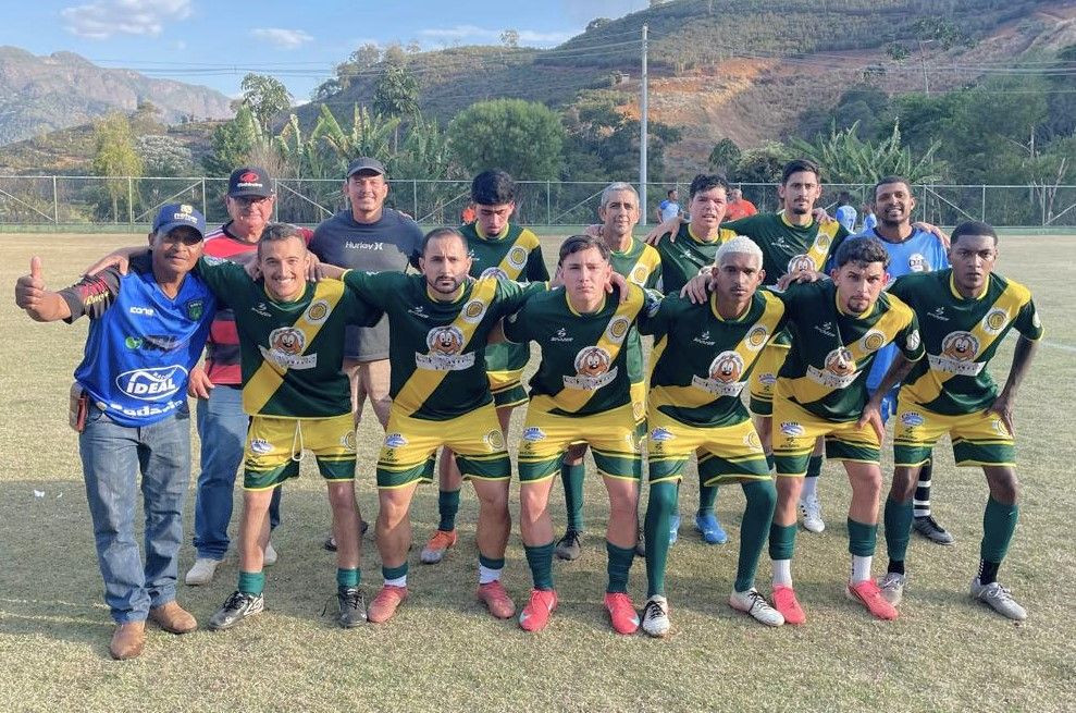 Fotografia da equipe do Bambu posando no gramado em duas fileiras, vestindo uniforme verde e amarelo com detalhes em dourado.