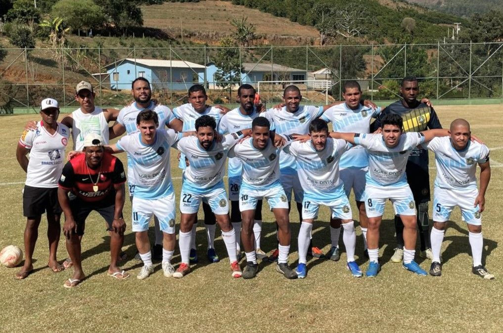 Fotografia dos jogadores do Real Bayer posando no gramado em duas fileiras, vestindo uniforme azul claro e branco com calções brancos.