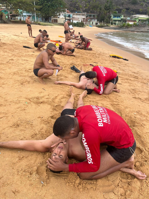 Participantes realizam treinamento prático de salvamento aquático durante atividade de formação de guarda-vidas em uma praia do Espírito Santo.
